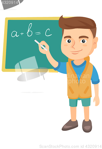 Image of Caucasian schoolboy writing on the blackboard.