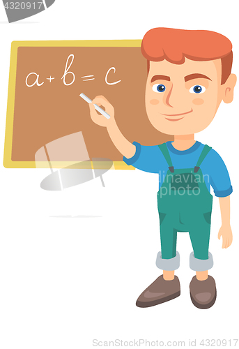 Image of Caucasian schoolboy writing on the blackboard.