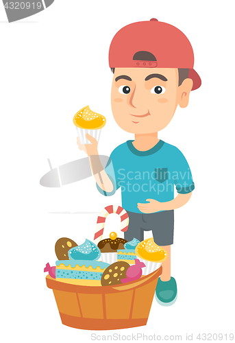 Image of Boy holding a cupcake and stroking his belly.