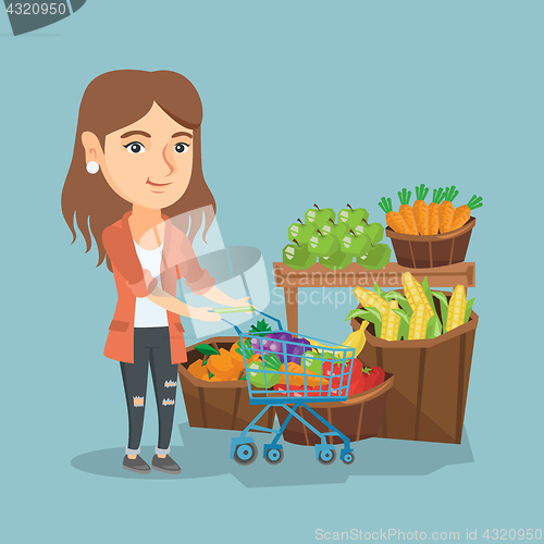 Image of Young caucasian woman pushing a supermarket cart.