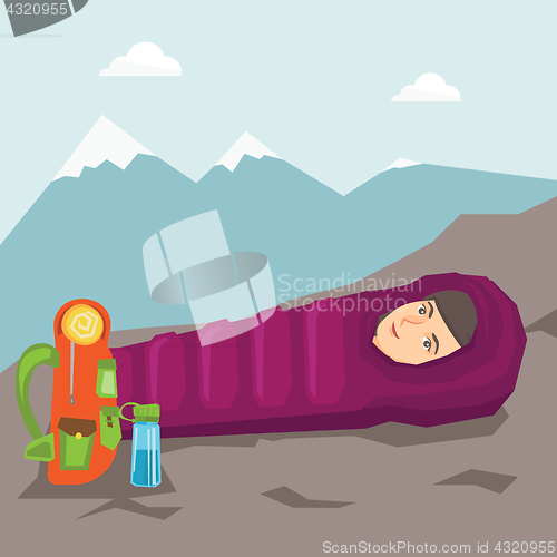 Image of Woman sleeping in a sleeping bag in the mountains.