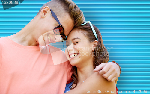 Image of happy teenage couple with sunglasses hugging