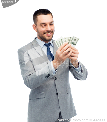 Image of smiling businessman counting american dollar money