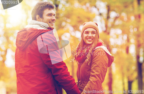 Image of happy young couple walking in autumn park