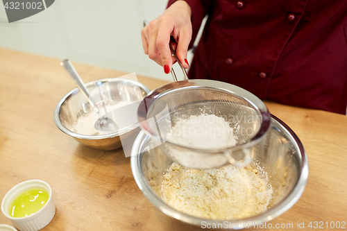 Image of chef sifting flour in bowl making batter or dough