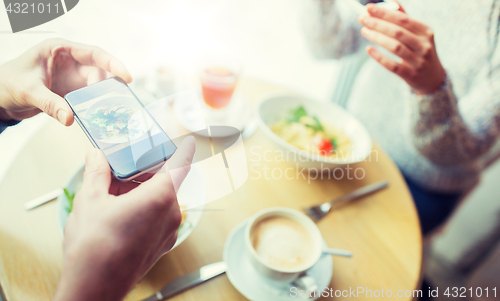 Image of close up of couple picturing food by smartphone