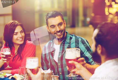 Image of friends dining and drinking beer at restaurant