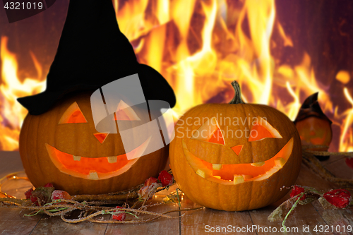 Image of carved halloween pumpkins on table over fire