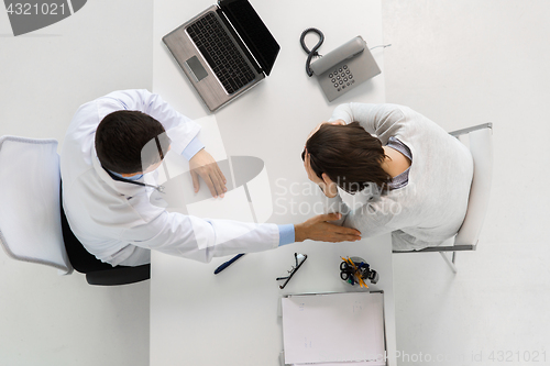Image of doctor with laptop and woman patient at hospital