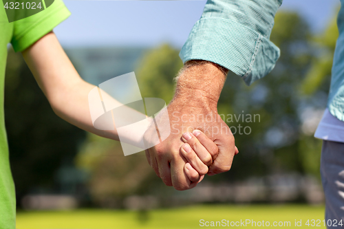 Image of senior man and child holding hands