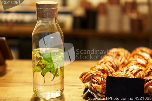 Image of fruit water in bottle and buns at grocery store