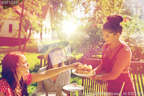 Image of happy friends having dinner at summer garden party