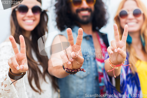 Image of happy young hippie friends showing peace outdoors