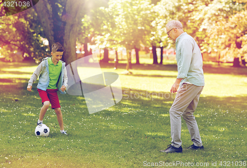 Image of old man and boy playing football at summer park