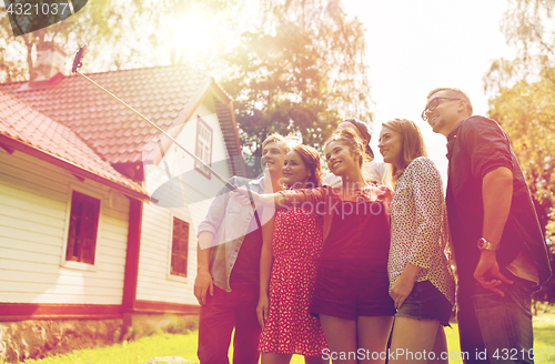 Image of friends taking selfie at party in summer garden