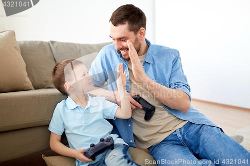 Image of father and son with gamepads doing high five