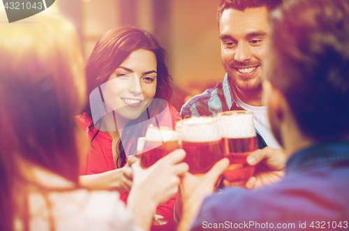 Image of friends drinking beer and clinking glasses at pub