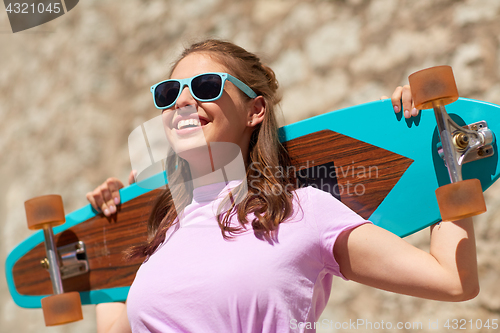 Image of happy teenage girl in shades with longboard