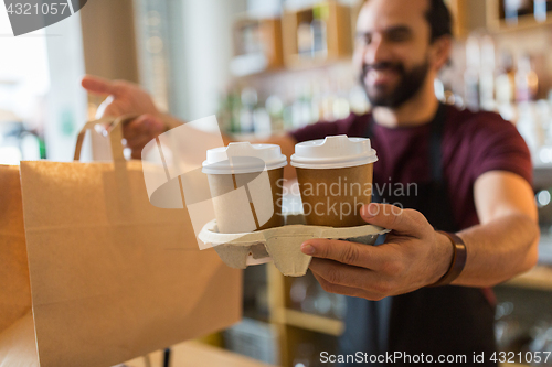 Image of man or bartender serving customer at coffee shop