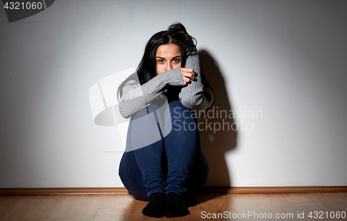 Image of unhappy woman crying on floor at home