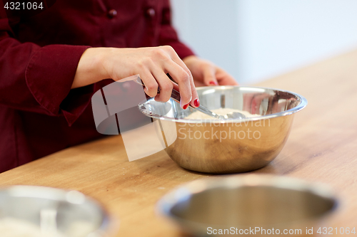 Image of chef with flour in bowl making batter or dough