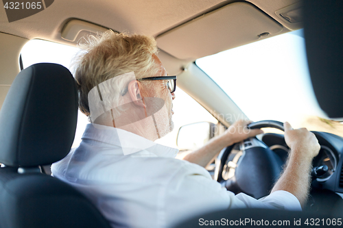 Image of happy senior man driving car