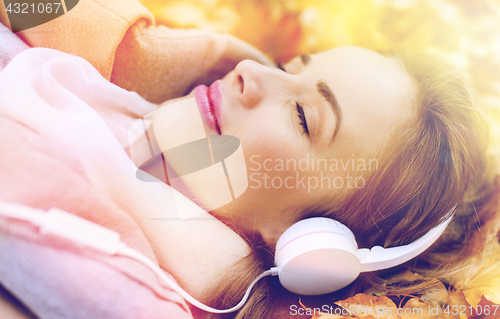 Image of woman with headphones listening to music in autumn