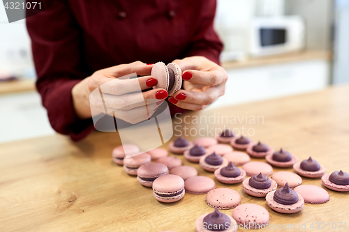 Image of chef sandwiching macarons shells with cream