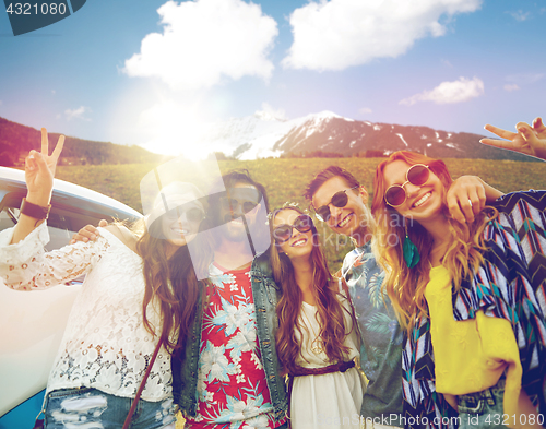 Image of hippie friends over minivan car showing peace sign