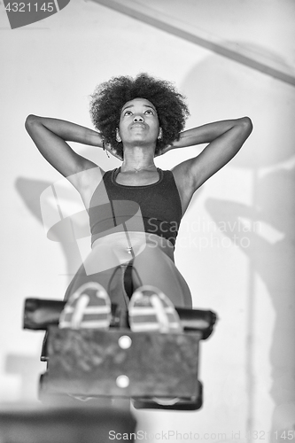 Image of black woman doing sit ups at the gym