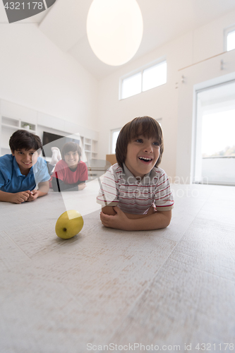 Image of boys having fun with an apple on the floor