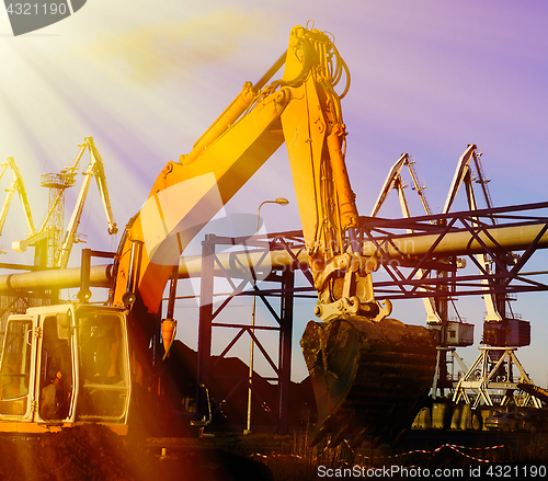 Image of Hydraulic excavator at work. Shovel bucket against blue sky