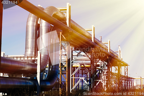 Image of industrial pipelines on pipe-bridge against blue sky