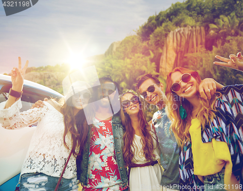 Image of hippie friends at minivan car showing peace sign