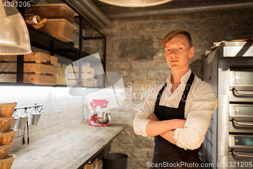 Image of chef or baker in apron at bakery kitchen