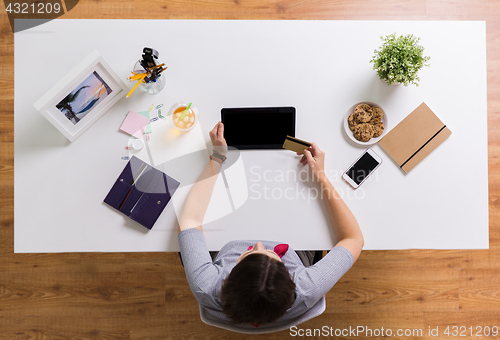 Image of woman with tablet pc and credit card at table