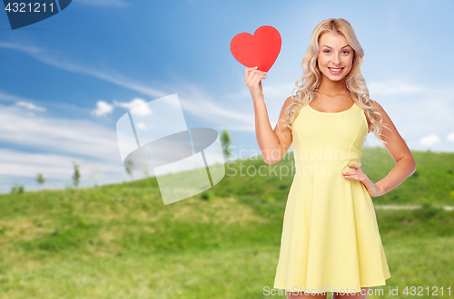 Image of happy young woman in summer dress with red heart