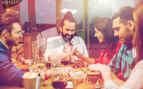 Image of friends eating and tasting food at restaurant