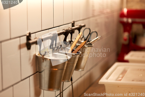 Image of bakery kitchen tools hanging on wall in buckets