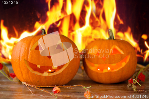 Image of carved halloween pumpkins on table over fire