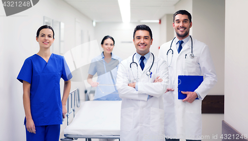 Image of group of happy doctors with gurney at hospital