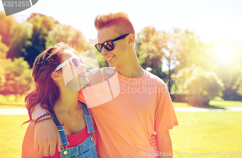 Image of happy teenage couple looking at each other in park