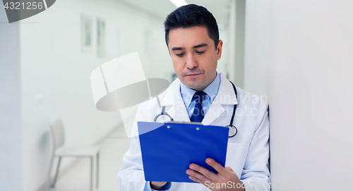 Image of doctor writing to clipboard at hospital