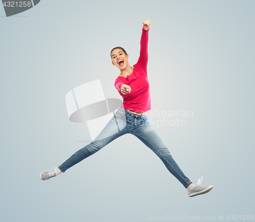 Image of smiling young woman jumping in air