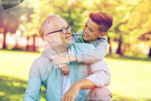 Image of grandfather and grandson hugging at summer park