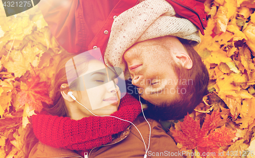 Image of close up of smiling couple lying in autumn park