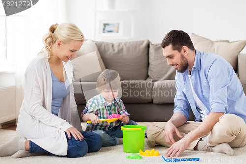 Image of happy family playing with beach toys at home