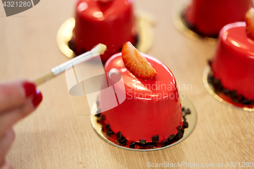 Image of chef decorating glaze cakes at pastry shop