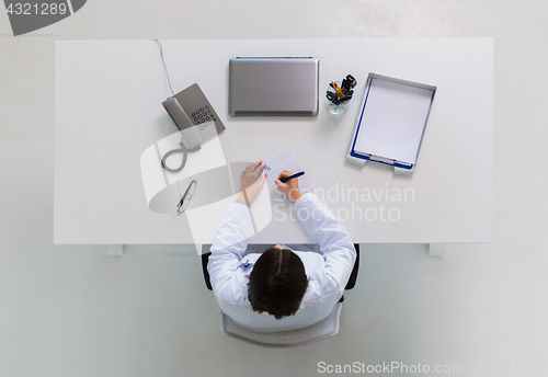 Image of doctor writing prescription at table