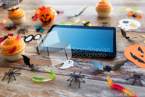 Image of tablet pc, halloween party decorations and treats